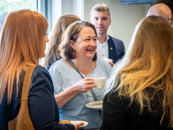 Vrouw lacht en praat met andere deelnemers tijdens MannekenBizz netwerkevent
